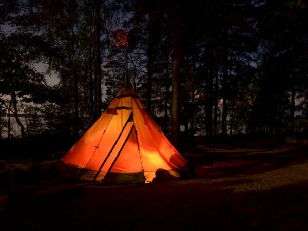Kvällsbild på upplyst tält vid Törestorps camping, Glasriket