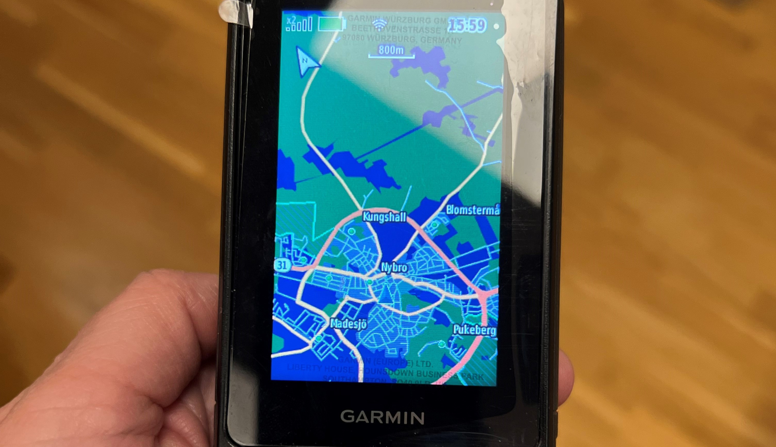 Primer plano de un GPS Garmin de mano que muestra un mapa del centro de Nybro.