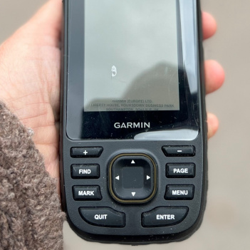 En hand som håller en Garmin GPS
